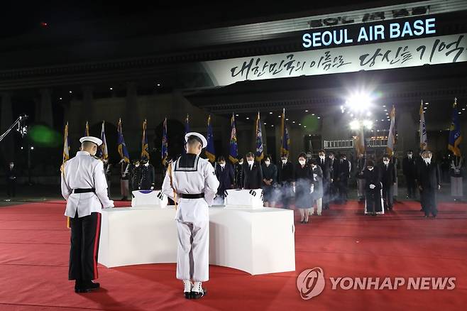 국군 전사자 유해에 묵념하는 문 대통령 (성남=연합뉴스) 최재구 기자 = 방미 일정을 마치고 귀국한 문재인 대통령과 김정숙 여사가 23일 밤 서울공항에서 열린 국군 전사자 유해 봉환식에서 함께 귀국한 국군 전사자 유해에 묵념하고 있다. 2021.9.23 jjaeck9@yna.co.kr