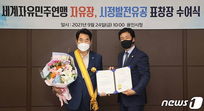 백군기 용인시장(왼쪽)이 24일 세계자유민주연맹으로부터 ‘자유장’을 수상하고 있다.(용인시 제공) © News1