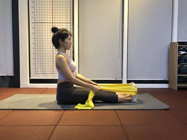 발을 탄성밴드 가운데에 위치시키고 밴드 양 끝을 손으로 잡는다. 피트니스위 제공