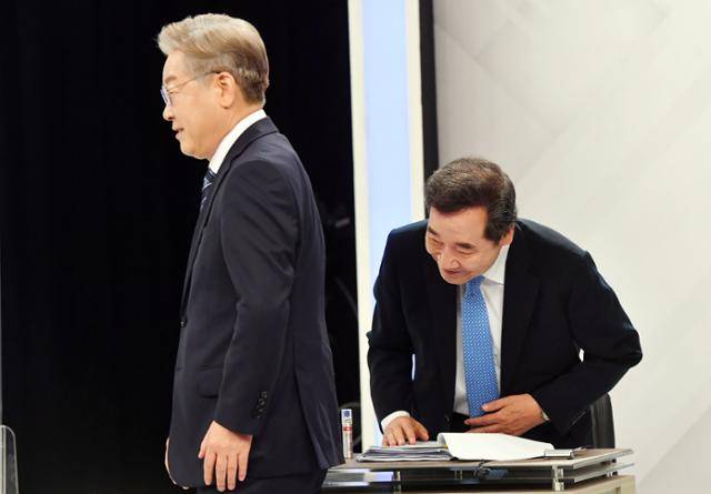 더불어민주당 대권 주자인 이재명(왼쪽), 이낙연 후보가 24일 오후 부산 수영구 부산KBS에서 열린 제20대 대통령선거 민주당 경선 후보 토론회에 참석, 인사를 나눈 뒤 각자의 자리에 앉고 있다. 뉴시스