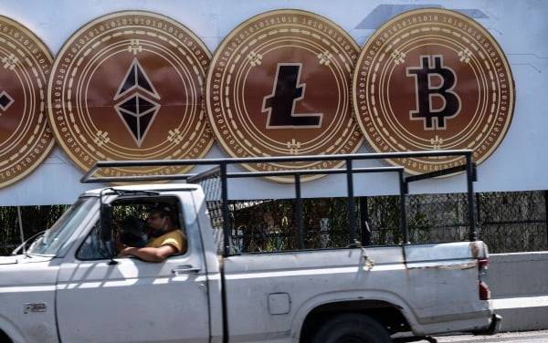 최근 암호화폐인 비트코인을 법정 화폐로 사용하기 시작한 베네수엘라의 수도 카라카스에서 한 운전자가 지난 17일 대형 비트코인 광고판 앞을 지나고 있다. AFP연합뉴스