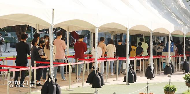 코로나19 신규 확진자가 2434명으로 역대 최다를 기록한 24일 서울광장 임시선별검사소에 아침부터 검사를 받으려는 시민들이 길게 줄지어 서 있다. 강윤중 기자