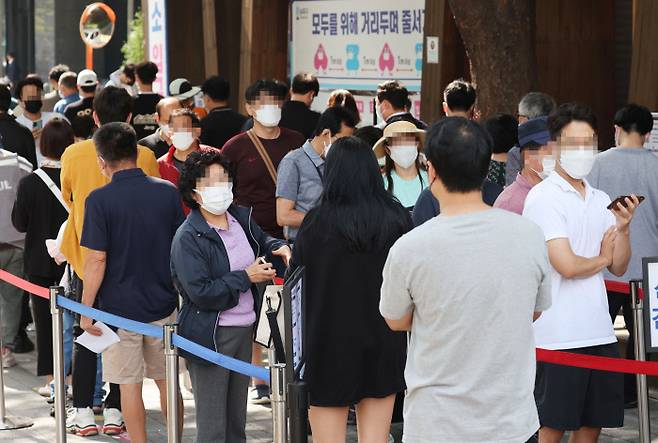 24일 오전 서울 송파구 보건소 선별진료소에서 시민들이 코로나19 검사를 받기 위해 줄지어 서있다. 연합뉴스
