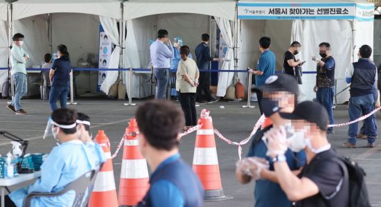 24일 서울 송파구 가락시장에 마련된 선별진료소에서 시민들이 코로나 19 검사를 위해 줄지어 서있다. [이미지출처=연합뉴스]