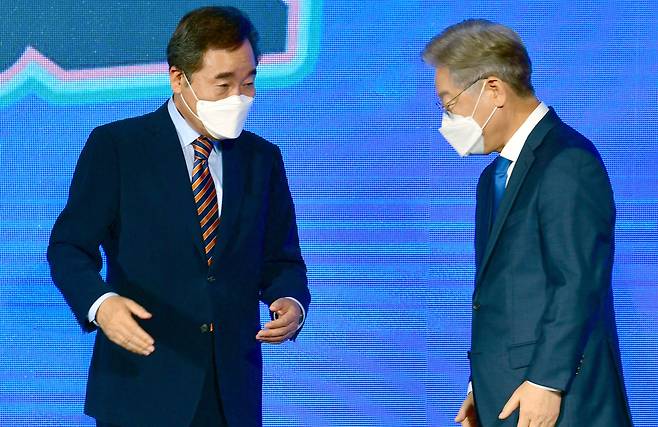 25일 더불어민주당 대선 후보 선출을 위한 광주·전남 합동연설회에서 투표 결과 발표 뒤 이낙연(왼쪽)·이재명 후보가 마주하고 있다. /뉴시스