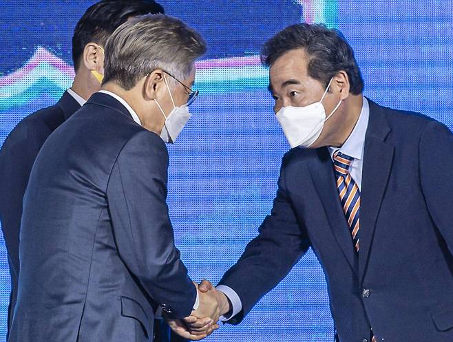 더불어민주당 대통령선거 후보자 선출을 위한 광주·전남 합동연설회가 열린 25일 오후 광주 서구 김대중컨벤션센터 1층 다목적홀에서 경선 득표 결과 발표 직후 이낙연(오른쪽) 후보가 이재명 후보와 악수하고 있다. 이날 광주·전남 경선에서는 이낙연 후보가 47.12%를 득표해 이재명 후보를 근소한 차이로 앞선 1위를 차지했다. [연합]