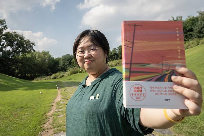 이연실 편집자가 자신이 편집한 책 <이웃집 퀴어 이반지하>(이반지하)를 들고 있다. 사진 이승원 작가