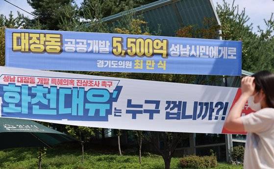 24일 경기도 성남시청 인근 교차로에 성남 대장동 개발 사업과 관련해 더불어민주당 소속 경기도의회 의원과 국민의힘 지역 당협위원장 이름으로 상반된 의미의 현수막이 나란히 걸려 있다. 2021.9.24   [연합뉴스]