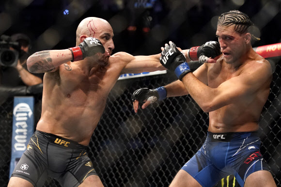 알렉산더 볼카노프스키(왼쪽)가 25일(현지시간) 미국 네바다주 라스베이거스에서 열린 UFC 266 메인 이벤트 페더급 경기에서 브라이언 오르테가에게 주먹을 날리고 있다.AP 연합뉴스