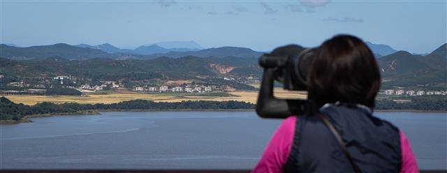 北 마을 살펴보는 관람객 - 북한 김여정 노동당 부부장이 연이틀 문재인 대통령의 종전선언 제의에 ‘긍정 담화’를 내놓은 가운데 26일 경기 파주 오두산통일전망대를 찾은 관람객이 북한 개풍군 마을을 살펴보고 있다.뉴스1