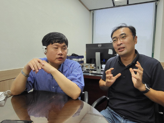 김용태(오른쪽) 강한손 대표와 하성준 한국시각장애인연합회 사무총장이 음성AI 기반 웨어러블 기기에 대해 설명하고 있다.   안경애 기자