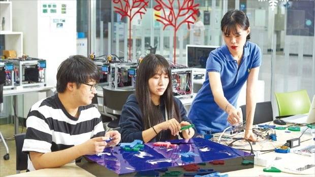 ETRI 연구진이 3차원(3D) 프린팅 테스트베드에서 제작한 모형을 두고 토론하고 있다. /ETRI 제공