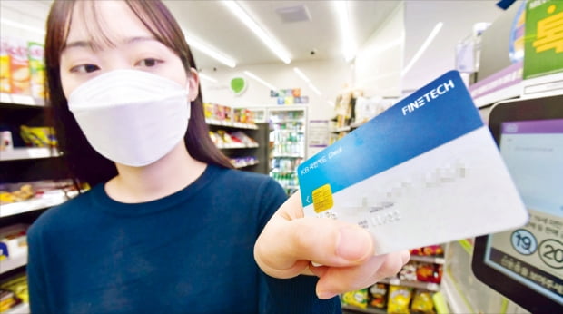 정부는 코로나19로 위축된 소비를 회복하기 위해 다음달부터 카드 사용을 늘리면 두 달간 최대 20만원의 캐시백을 지원하기로 했다. 한 소비자가 카드를 단말기에 대고 있다.  김영우  기자
