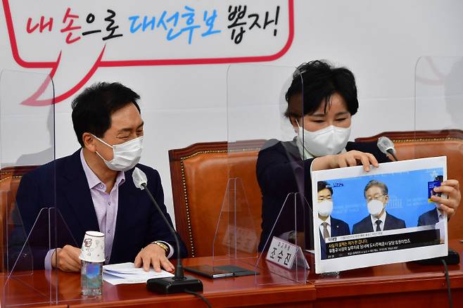 김기현 국민의힘 원내대표(왼쪽)가 27일 국회에서 열린 최고위원회의에서 조수진 최고위원이 자신의 자리에 올려놓는 여권 유력 대선후보 이재명 경기지사의 사진을 바라보고 있다.  국회사진기자단