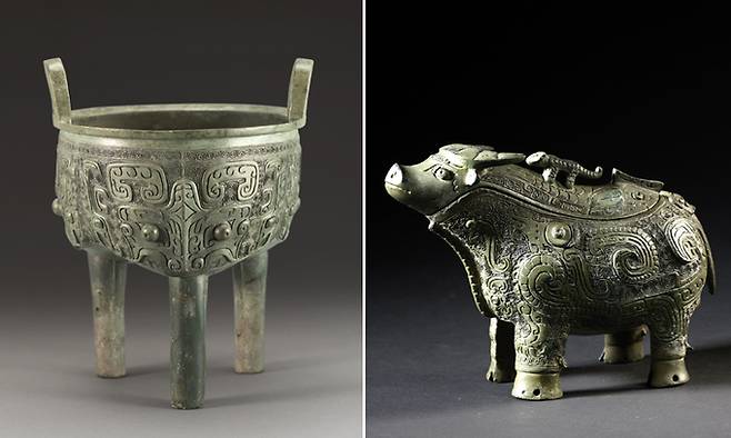 국립중앙박물관 특별전 ‘중국 고대 청동기’에 출품된 세발솥(왼쪽 사진)과 소 모양의 술통. 세발솥에는 전설 속 괴수인 도철이, 술통에는 봉황이 새겨져 있어 고대 중국인들이 청동기를 통해 표현한 신숭배의 관념을 읽을 수 있다. 국립중앙박물관 제공