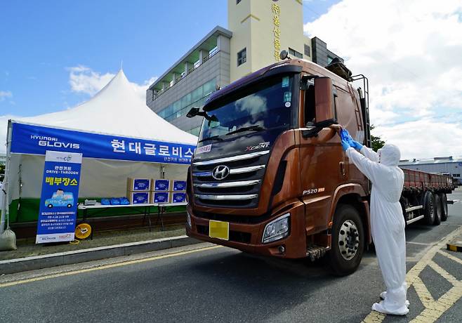 현대글로비스 관계자가 지난 27일 울산화물터미널을 이용하는 화물차 운전자에게 안전용품세트를 전달하고 있다. 사진제공=현대글로비스