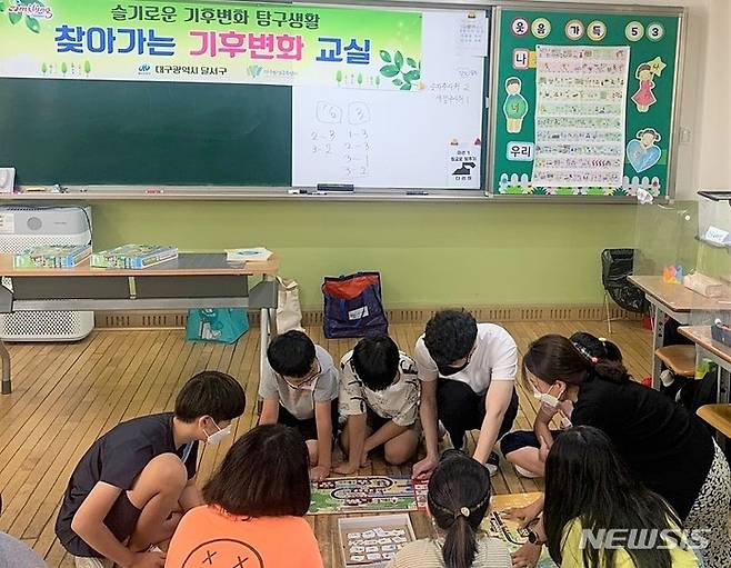 기후변화 교실에서 학생들이 보드게임을 하고 있다