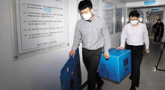 압수수색 - 경기 성남시 대장동 개발 의혹 사건과 관련해 29일 성남도시개발공사를 압수수색한 검찰 관계자들이 압수품을 들고 나오고 있다. /장련성 기자