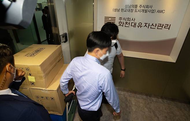 29일 오후 경기도 성남시 화천대유자산관리 사무실에서 압수수색을 마친 검찰 관계자들이 압수품을 옮기고 있다.      검찰은 경기 성남시 대장동 개발사업의 특혜 의혹을 받는 자산관리회사 화천대유와 관련자들의 사무실·주거지 등을 압수수색하며 본격 수사에 착수했다. 2021.9.29 /오종찬 기자