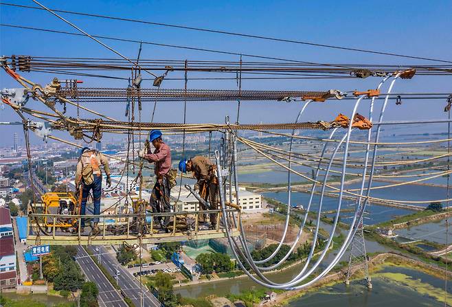 중국이 최근 심각한 전력난을 겪고 있는 가운데 27일 장쑤성 우시의 송전선에서 근로자들이 작업하고 있다. 2021.09.28/연합뉴스