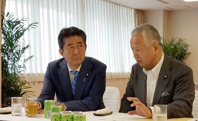 아베 신조 전 총리(왼쪽)와 아마리 아키라 당 세제조사회장. 아마리 누리집 갈무리