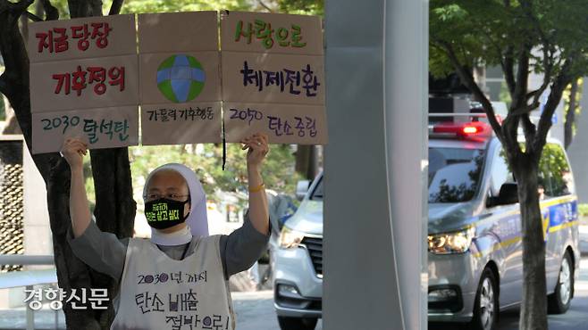 가톨릭기후행동 공동대표인 임미정 살루스 수녀가 30일  4대 종단 종교위원들의 사퇴 회견이 열린  서울 광화문 탄중위 입주 건물 앞에서 탈석탄·탄소중립 등 구호를 적은 종이 박스를 들고 구회를 외치고 있다. 김종목 기자