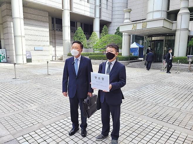 SK브로드밴드가 30일 넷플릭스를 상대로 망 이용대가 청구를 위한 반소를 제기한 가운데, SK브로드밴드 관계자가 서울중앙지방법원 서관 앞에서 반소장을 들고 반소 배경을 설명하고 있다. [SK브로드밴드 제공]