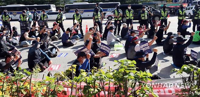 결의대회 하는 민주노총 공공운수노조 (청주=연합뉴스) 천경환 기자 = 30일 오전 청주시 흥덕구 송정동 SPC삼립 청주공장 앞 도로에서 민주노총 공공운수노조가 결의대회를 열고 있다. 화물연대는 세종공장에서 결의대회를 하려다 강제해산 당하자 청주공장 앞에 재결집해 철야 농성을 벌였다. 이들은 과도한 업무량을 개선하기 위한 증차와 배송노선 조정 등을 요구하고 있다. 2021.9.30 kw@yna.co.kr