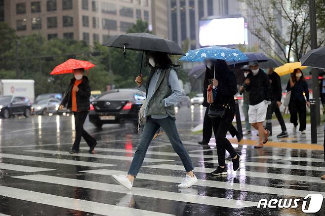 서울 세종대로 사거리에서 우산을 쓴 시민들이 발걸음을 재촉하고 있다.© News1 황기선 기자