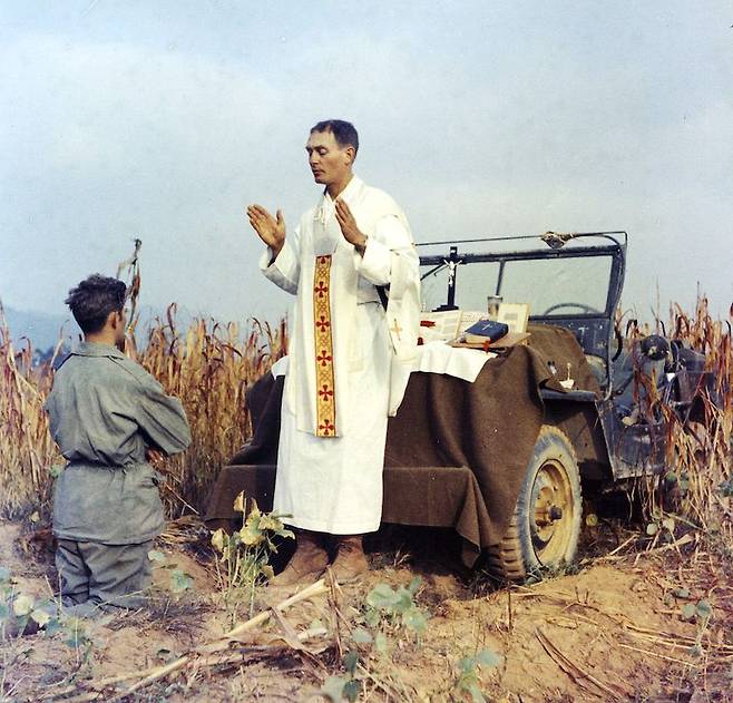 In this photo provided by Col. Raymond A. Skeehan, Father Emil Kapaun celebrates Mass using the hood of his jeep as an altar, as his assistant, Patrick J. Schuler, kneels in prayer in Korea on Oct. 7, 1950, less than a month before Kapaun was taken prisoner. Kapaun died in a prisoner of war camp on May 23, 1951, his body wracked by pneumonia and dysentery. On April 11, 2013, President Barack Obama will award the legendary chaplain, credited with saving hundreds of soldiers during the Korean War, the Medal of Honor posthumously. (AP Photo/Col. Raymond A. Skeehan via The Wichita Eagle)