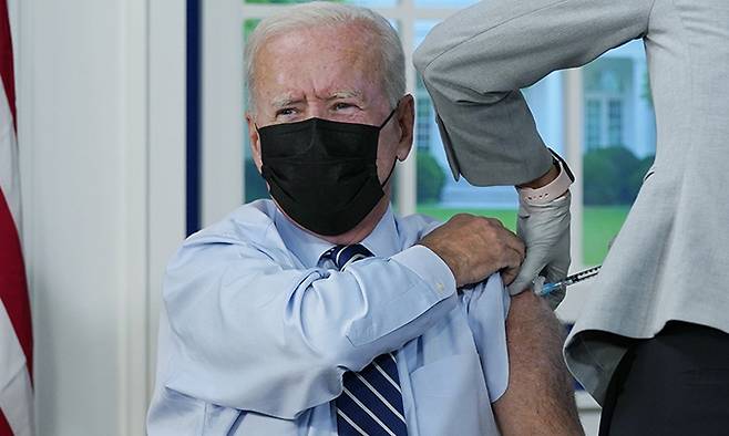 조 바이든 미국 대통령이 27일(현지시간) 백악관 청사 사우스 코트 강당에서 코로나19 백신 부스터 샷을 접종하고 있다. 워싱턴=AP뉴시스