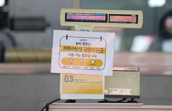 전 국민의 약 88%가 1인당 25만원씩 받는 코로나 상생 국민지원금(재난지원금) 지급 절차가 시작된 지난달 6일 서울 용산구 전통시장의 한 가게에 코로나 상생 국민지원금 사용 가능 안내 문구가 붙어있다. /연합뉴스