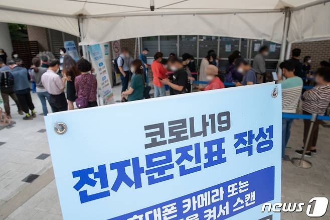 4일 오후 서울 마포구보건소에 마련된 신종 코로나바이러스 감염증(코로나19) 선별진료소를 찾은 시민들이 검체검사를 받기 위해 줄을 서 있다. 중앙재난안전대책본부는 마포농수산물시장에서 발생한 코로나19 집단감염과 관련해 시장 종사자 및 방문자에 대해 검체검사를 받을것을 요청했다. 2021.10.4/뉴스1 © News1 이재명 기자