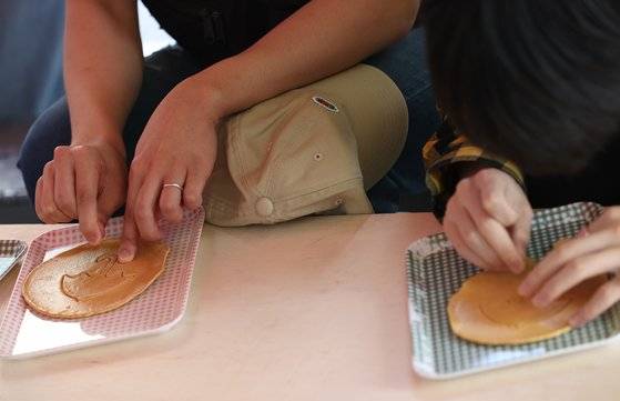 지난달 30일 오후 서울 종로구 대학로의 한 뽑기 가게에서 시민들이 뽑기를 즐기고 있다. [연합뉴스]