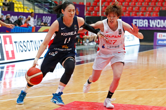 Korea's forward Kang Lee-seul, left, drives to the basket against Japan's shooting guard Saki Hayashi during the 2021 FIBA Women's Asia Cup Group A basketball match between Japan and Korea in Amman, Jordan on Sept. 29. [AFP/YONHAP]