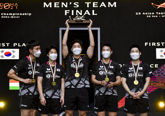 The Korean men's team celebrate on the podium after winning the men's team final between Korea and Chinese Taipei at the 2021 ITTF-ATTU Asian Championships Doha in Doha, Qatar on Friday. [XINHUA/YONHAP]