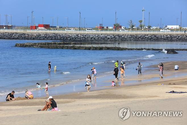 다시 돌아온 여름 (제주=연합뉴스) 박지호 기자 = 낮 기온이 30도를 넘어선 5일 오후 제주시 이호동 이호해수욕장을 찾은 관광객이 물놀이하고 있다. 2021.10.5 jihopark@yna.co.kr