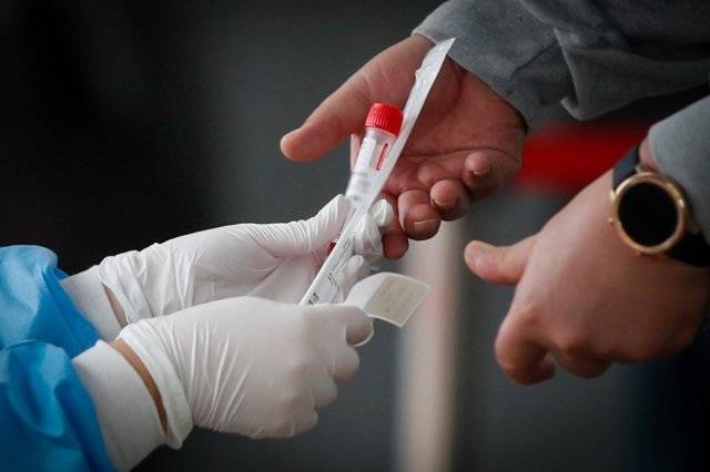 6일 오전 서울역 광장에 마련된 중구 임시선별진료소에서 관계자가 시민에게 검체채취 도구를 배부하고 있다. 2021.10.6/뉴스1