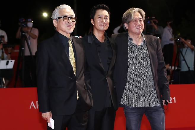 From left: Im Sang-soo, Park Hye-il and Choi Min-sik pose on the red carpet before entering the Busan Cinema Center for the 26th Busan International Film Festival’s opening ceremony on Wednesday night. (Yonhap)