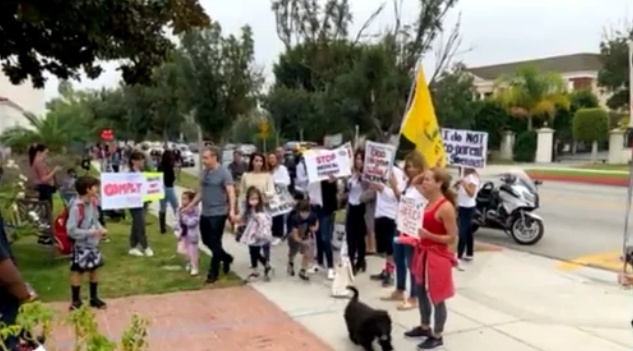 미국의 마스크 착용 반대 시위대가 캘리포니아주 베벌리힐스의 한 초등학교 앞에서 마스크 착용은 아동학대와 같다고 주장했다.