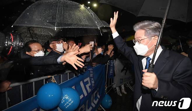 더불어민주당 제20대 대통령선거 후보에 선출된 이재명 경기지사가 10일 오후 서울 송파구 올림픽공원 SK올림픽핸드볼경기장에서 열린 서울 지역 경선 및 3차 국민선거인단 투표에서 1위를 차지한 뒤 행사장 밖 지자자들의 축하를 받고 있다. 이 후보는 서울 지역 경선에서 51.45%를 얻어 누적 득표율 50.29%를 기록, 결선 투표 없이 더불어민주당 20대 대통령 선거 후보에 선출됐다. 2021.10.10/뉴스1 © News1 국회사진취재단