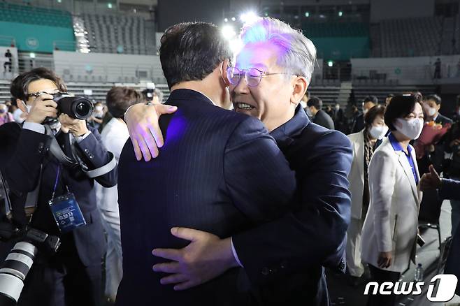 더불어민주당 제20대 대통령선거 후보에 선출된 이재명 경기지사가 10일 오후 서울 송파구 올림픽공원 SK올림픽핸드볼경기장에서 열린 서울 지역 경선 및 3차 국민선거인단 투표에서 1위를 차지한 뒤 송영길 대표와 포옹하고 있다. 이 후보는 서울 지역 경선에서 51.45%를 얻어 누적 득표율 50.29%를 기록, 결선 투표 없이 더불어민주당 20대 대통령 선거 후보에 선출됐다. 2021.10.10/뉴스1 © News1 국회사진취재단