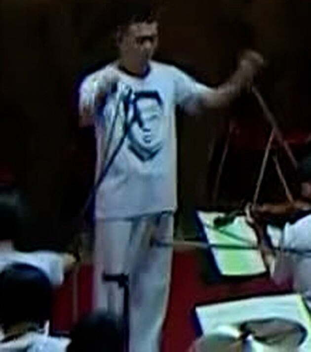 지난 11일 열린 국방발전전람회 '자위-2021'에서 음악 연주를 지휘하는 북한 지휘자의 티셔츠에 김정은 북한 국무위원장 얼굴이 그려져 있다./ 연합뉴스