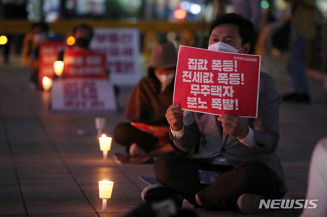 [서울=뉴시스] 조성우 기자 = 13일 오후 서울 종로구 보신각 앞에서 '무주택자 공동행동' 주최로 열린 '무주택자 집값 폭등 규탄 촛불집회' 참가자들이 촛불을 들고 있다. 2021.10.13. xconfind@newsis.com