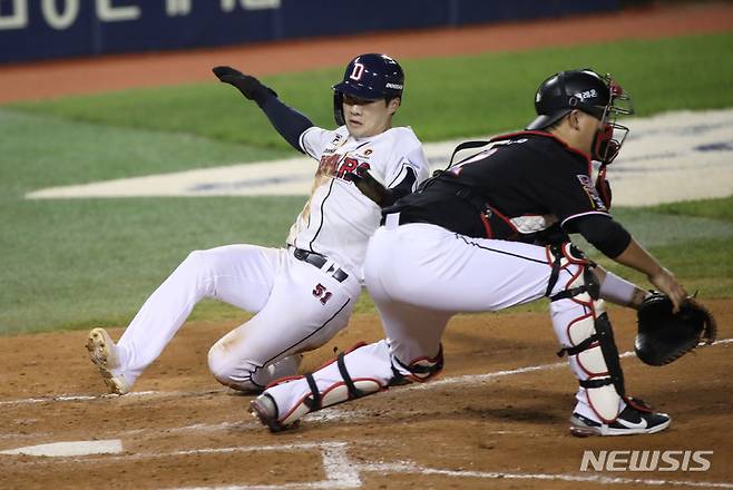 [서울=뉴시스] 고범준 기자 = 13일 오후 서울 송파구 잠실야구장에서 열린 2021 KBO리그 kt wiz와 두산 베어스의 경기, 7회말 1사 3루 두산 박건우의 희생플라이 아웃 때 3루주자 조수행이 홈을 밟고 있다. 2021.10.13. bjko@newsis.com