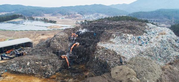 지난해 1월 17일 오전 경북 의성군 단밀면에 있는 쓰레기 산에서 포클레인들이 삽질할 때마다 뿌연 연기가 피어오르고 있다. /고운호 기자