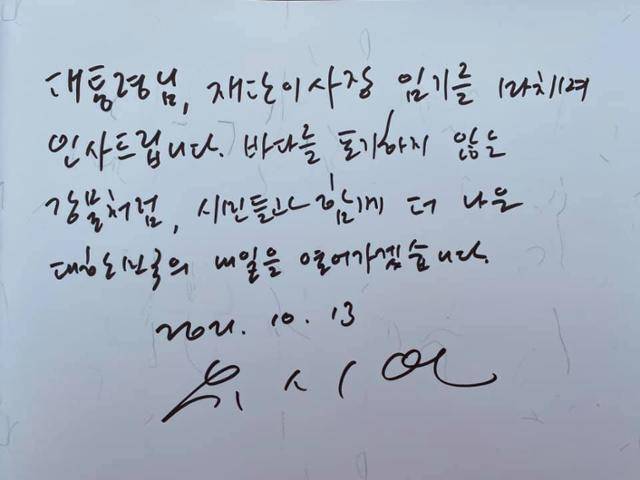 유시민 노무현재단 이사장이 13일 경남 김해시 진영읍 봉하마을에 있는 고 노무현 전 대통령 묘역에 참배하며 방명록에 적은 내용. 유 이사장이 적은 '바다를 포기하지 않는 강물처럼'은 노 전 대통령이 처음 썼던 표현이다. 사람사는 세상 봉하마을 페이스북 캡처