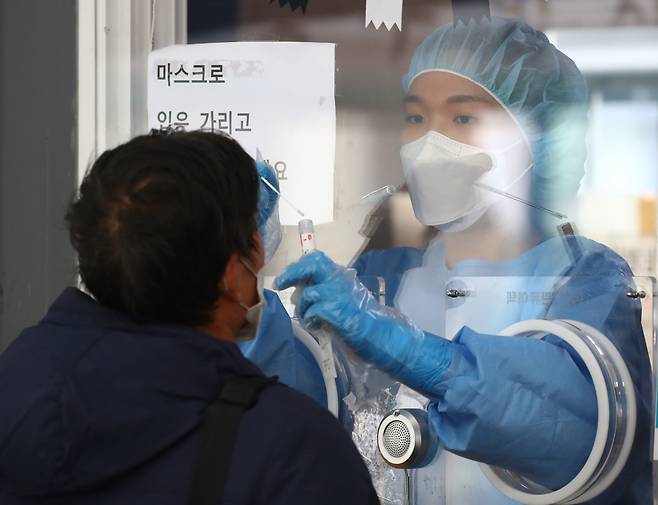 14일 오전 서울역 광장에 마련된 코로나19 임시선별검사소에서 의료진이 검체 채취를 하고 있다. [연합]