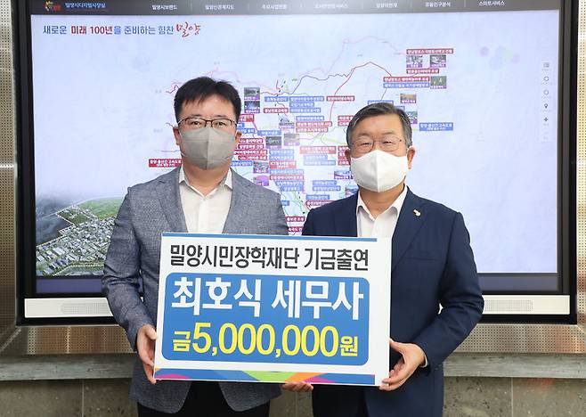 최호식(왼쪽) 세무사가 우수한 인재 발굴 양성을 위한 장학기금 500만원을 박일호 시장에게 전달하고 있다. *재판매 및 DB 금지