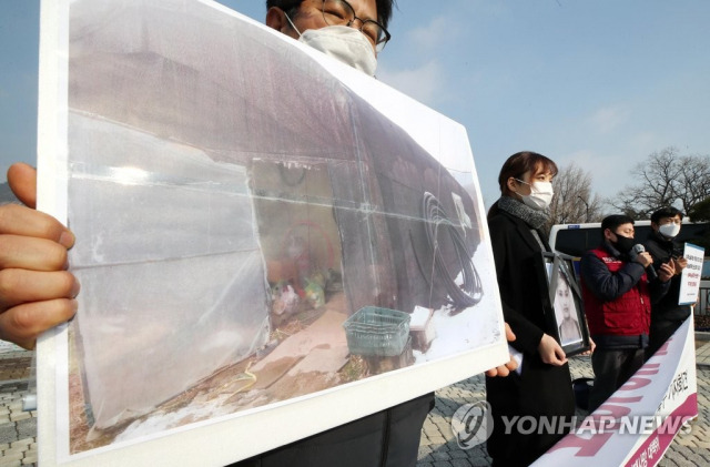 작년 12월 28일 청와대 분수대 앞에서 열린 '이주노동자 비닐하우스 숙소 산재사망 진상 규명 및 대책 마련 촉구 기자회견'에서 참석자가 같은 달 20일 목숨을 잃은 캄보디아 출신 여성노동자의 숙소 사진을 들고 있다./ 연합뉴스